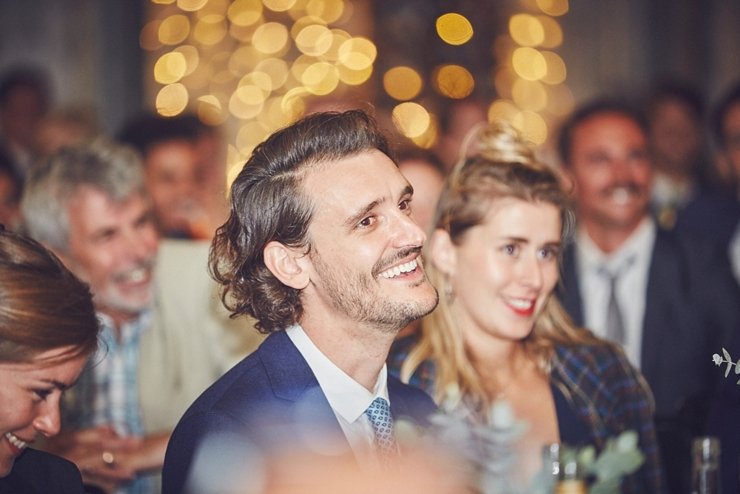 guest laughing at wedding speeches at festival style barn wedding in devon