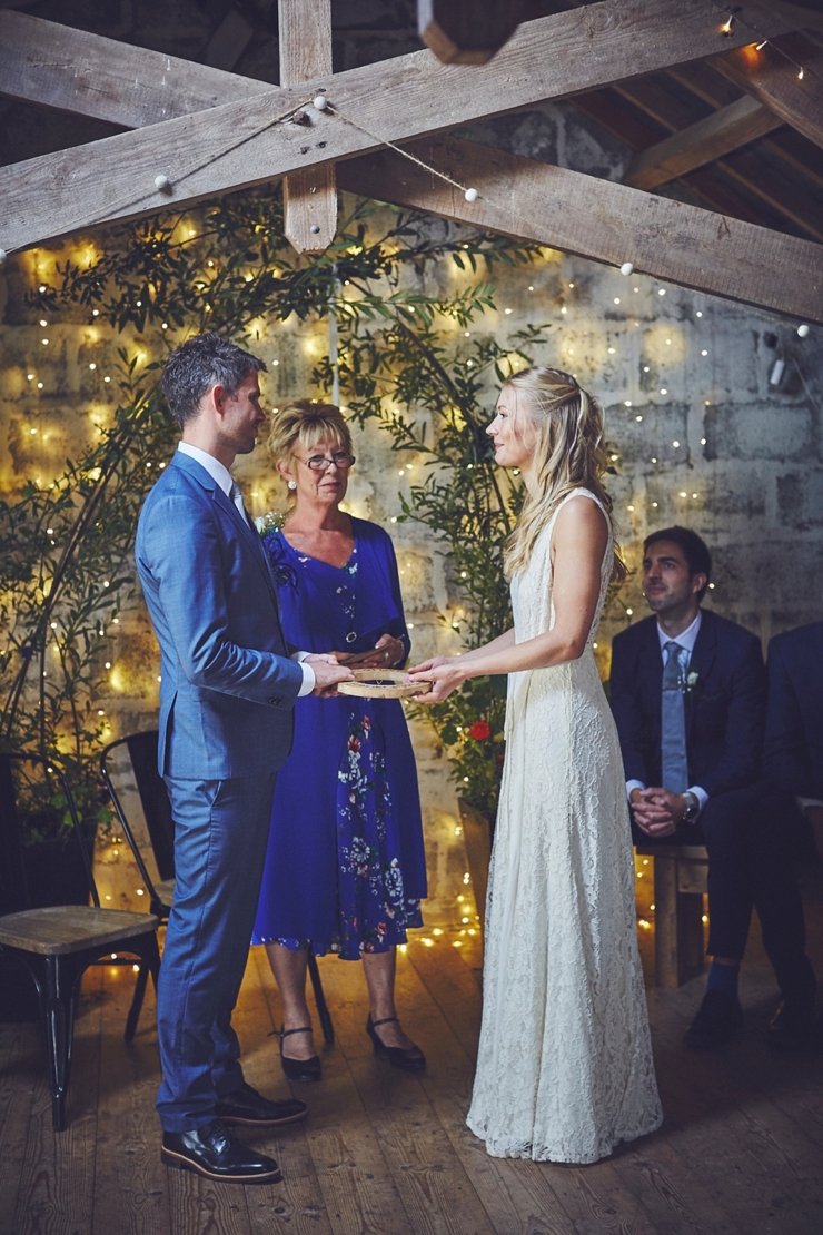 bride and groom hold wooden circle of love at humanist ceremony at East Soar in Devon