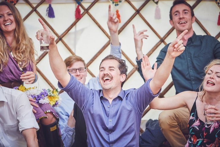 happy guest with cool moustache singing at a diy tipi wedding in Dorset